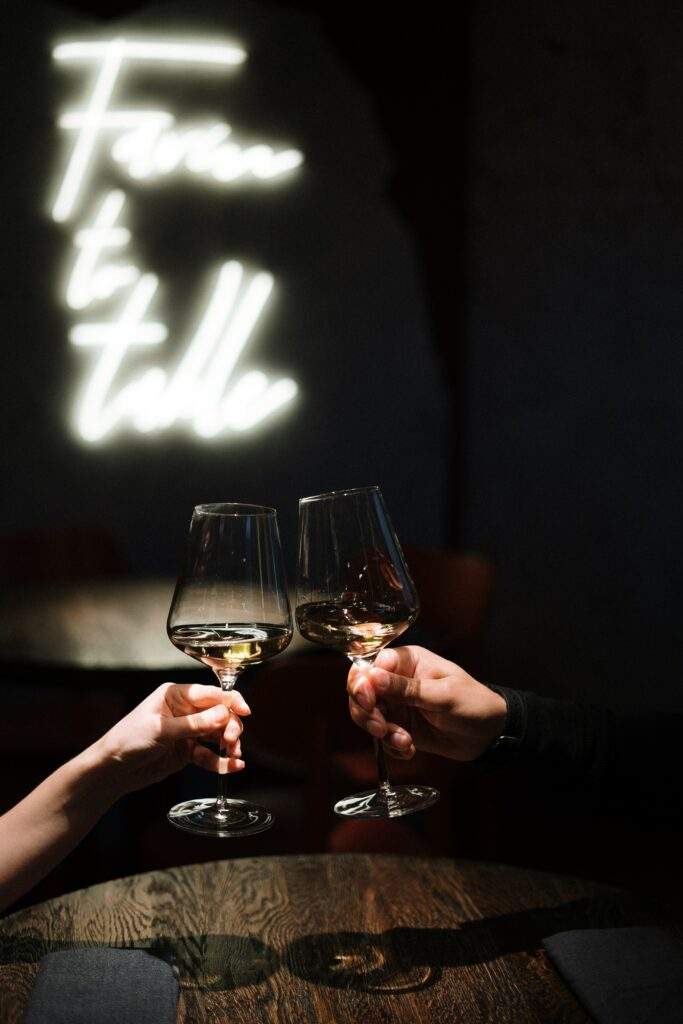 wine glasses touching in dark background