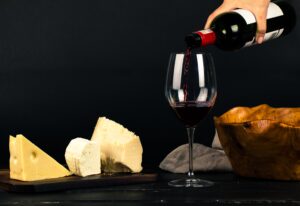 Wine and Cheese, Wine being poured into a glass cheese beside