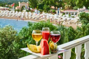 wine regions, colorful full wine glasses on balcony ledge with beach view